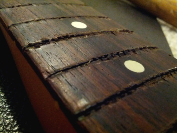 Close-up of naked fretless neck. Very dry wood.